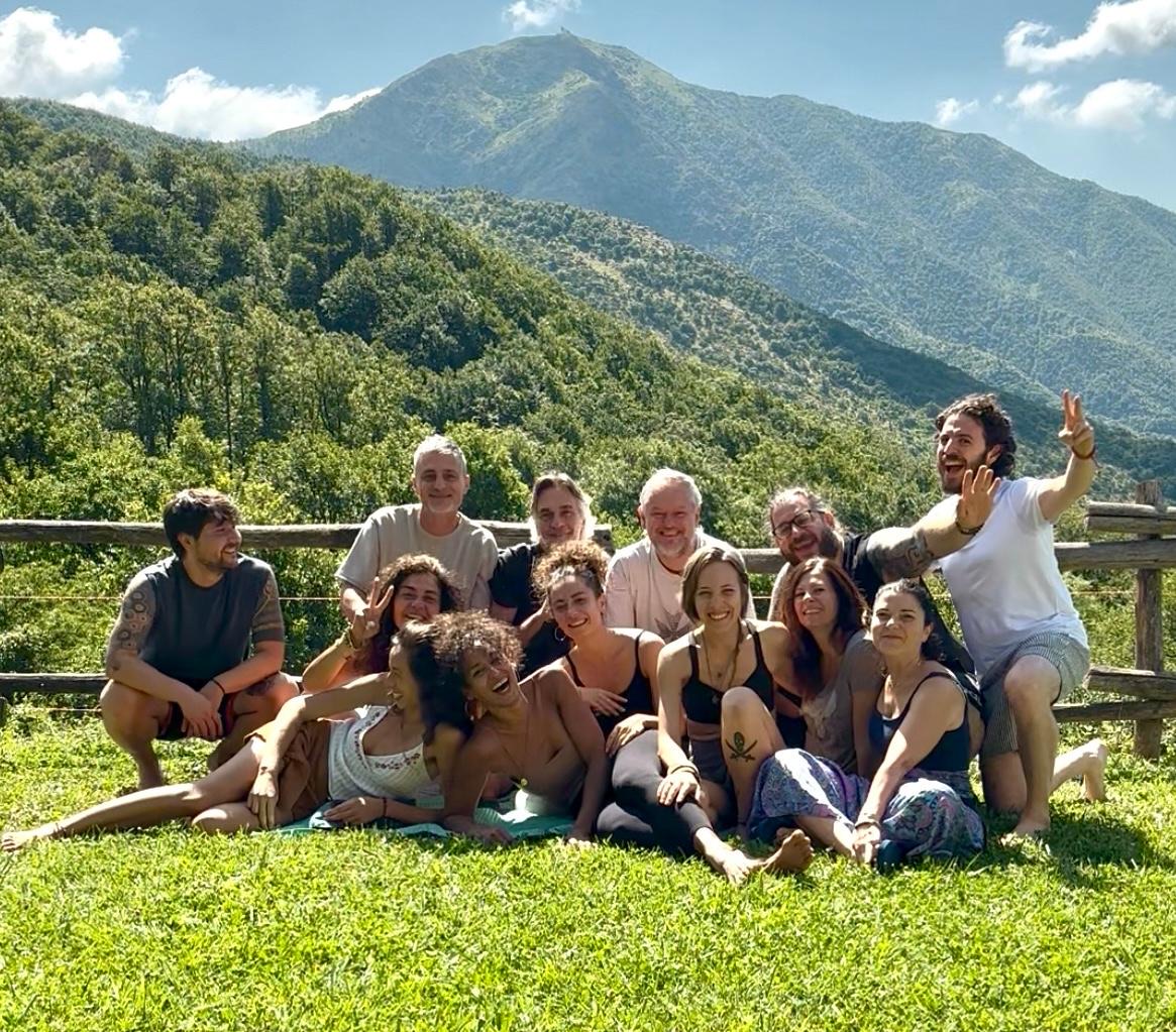 Il gruppo di un Campo di Alleanze Evolutive, sorridente all'aperto davanti alla montagna